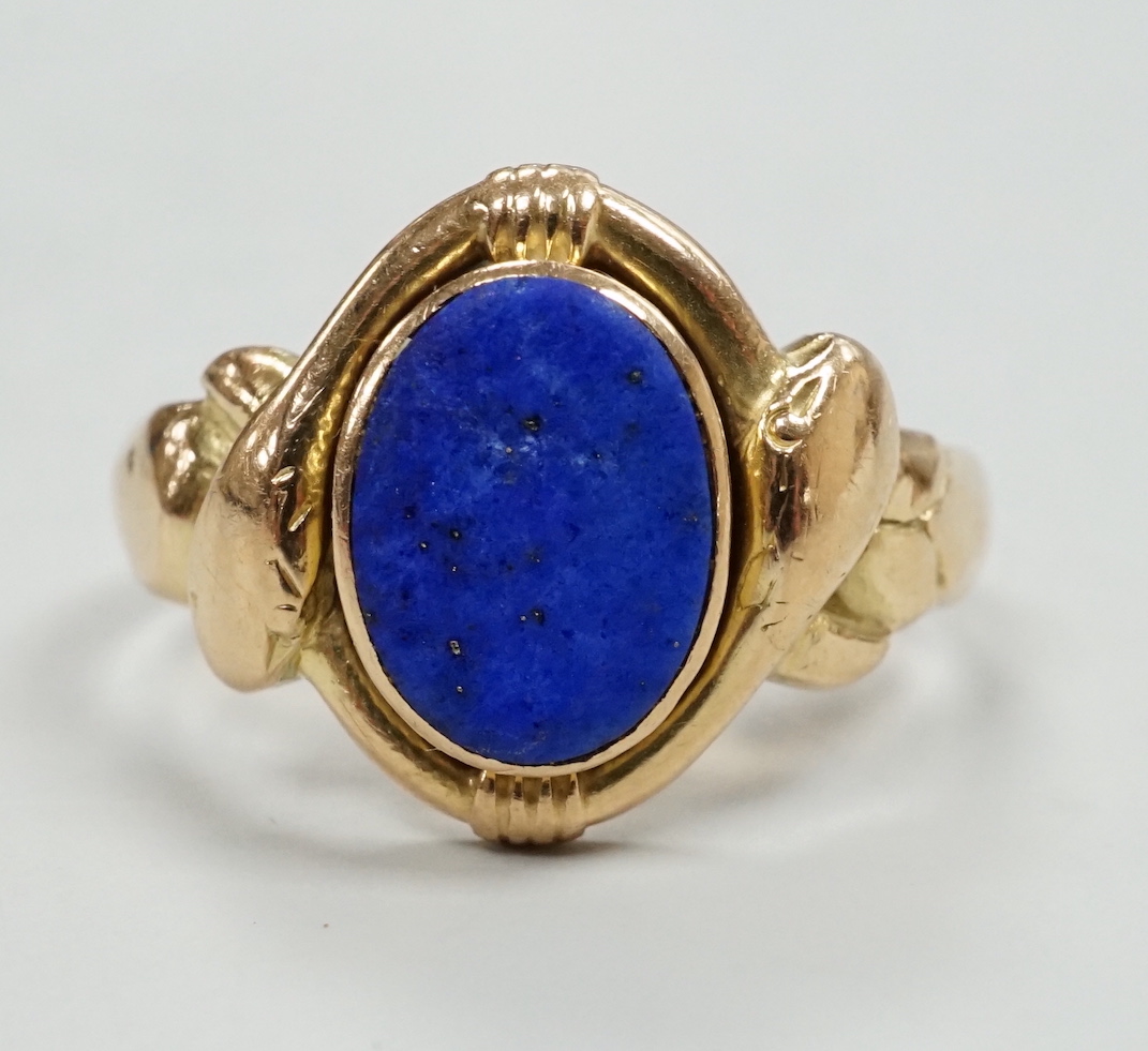 A 585 and lapis lazuli set ring, with twin serpent head terminals, size Q, gross weight 6.2 grams.